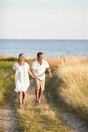 simsearch:6102-08329857,k - Happy couple walking at sea Stock Photo - Premium Royalty-Free, Code: 6102-08388361