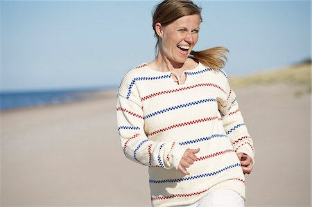 simsearch:6102-08481170,k - Happy woman jogging on beach Foto de stock - Royalty Free Premium, Número: 6102-08329743