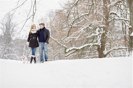 Couple walking dog through winter park Stock Photo - Premium Royalty-Free, Code: 6102-08329802