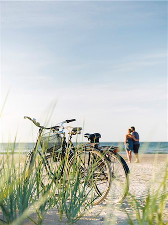 simsearch:6102-08271758,k - Bicycles on beach, couple on background Photographie de stock - Premium Libres de Droits, Code: 6102-08481137