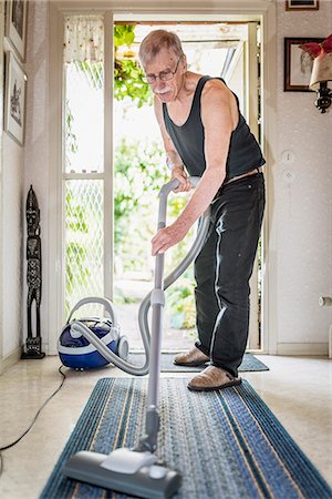 simsearch:6102-08120934,k - Senior man vacuuming at home Foto de stock - Sin royalties Premium, Código: 6102-08481369
