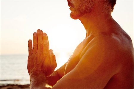 Mid-section of man meditating on beach Stock Photo - Premium Royalty-Free, Code: 6102-08481322