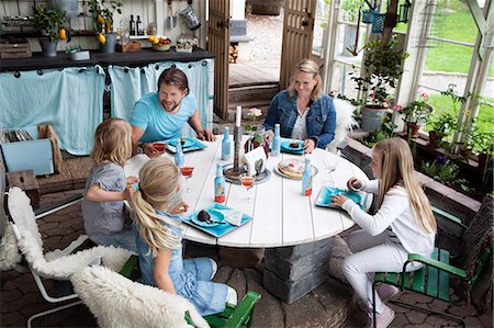 person relaxing in a greenhouse - Family with three children eating dessert Stock Photo - Premium Royalty-Free, Code: 6102-08481569