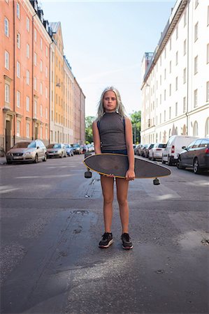 simsearch:6102-08480903,k - Girl standing in street, holding skateboard Photographie de stock - Premium Libres de Droits, Code: 6102-08481506