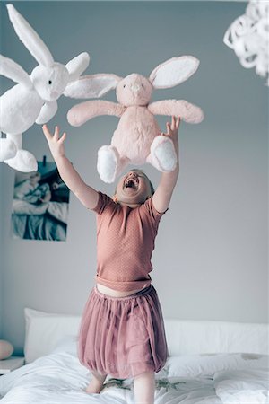 simsearch:6102-07842733,k - Laughing girl on bed Foto de stock - Royalty Free Premium, Número: 6102-08542150