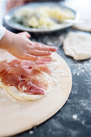 Child helping with making pizza Stock Photo - Premium Royalty-Free, Code: 6102-08542354
