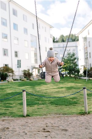simsearch:6102-07602862,k - Boy having fun on swing in playground Foto de stock - Sin royalties Premium, Código: 6102-08542359
