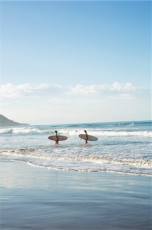 simsearch:6118-09144991,k - Teenage girls walking with surfboards in sea Stock Photo - Premium Royalty-Free, Code: 6102-08542371