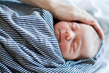 simsearch:877-08079172,k - Fathers hand holding head of sleeping baby Stock Photo - Premium Royalty-Free, Code: 6102-08558783
