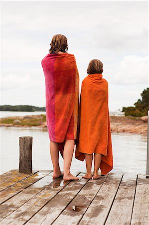 scandinavia lake friends - Two girls wrapped in towels standing on jetty Foto de stock - Sin royalties Premium, Código: 6102-08558797