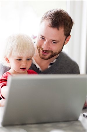 simsearch:6102-08566142,k - Father and baby son looking at laptop Foto de stock - Royalty Free Premium, Número: 6102-08558867