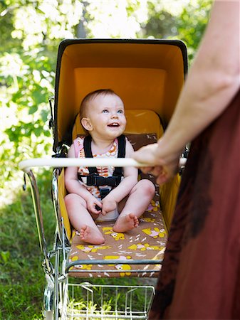 Baby looking at mother from pushchair Stock Photo - Premium Royalty-Free, Code: 6102-08558807