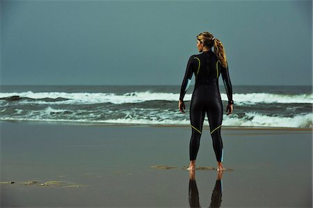 simsearch:6102-03748647,k - Young woman wearing wetsuit and standing on beach Stockbilder - Premium RF Lizenzfrei, Bildnummer: 6102-08558969