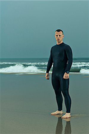 simsearch:6102-07768988,k - Man wearing wetsuit and standing on beach Stock Photo - Premium Royalty-Free, Code: 6102-08558980