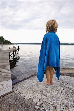 Boy wrapped in towel looking at view Stock Photo - Premium Royalty-Free, Code: 6102-08558990