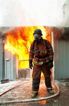 firefighter outdoors - Fire fighter in front of burning buildings Foto de stock - Sin royalties Premium, Código: 6102-08558916
