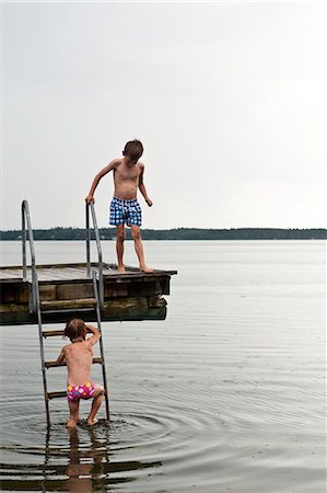 Two boys on jetty by sea Photographie de stock - Premium Libres de Droits, Code: 6102-08559072