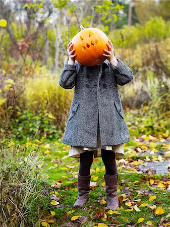 simsearch:6102-08001027,k - Girl hiding behind Jack Olantern Foto de stock - Royalty Free Premium, Número: 6102-08559092