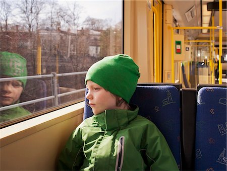 simsearch:6102-07843643,k - Boy in tram looking through window Photographie de stock - Premium Libres de Droits, Code: 6102-08559098