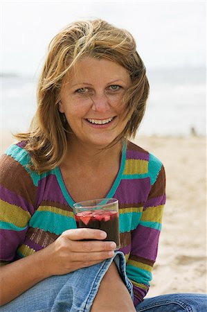 simsearch:6102-08542248,k - Woman with a glass of sangria on the beach, Sweden. Foto de stock - Royalty Free Premium, Número: 6102-08559614