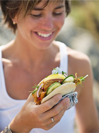 simsearch:6102-08559615,k - Woman eating at a picnic, Sweden. Photographie de stock - Premium Libres de Droits, Code: 6102-08559618