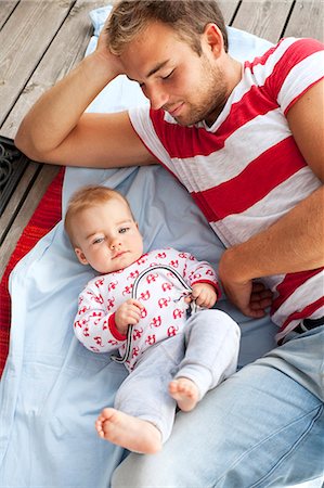 simsearch:6102-08566142,k - Father and baby lying on jetty Foto de stock - Royalty Free Premium, Número: 6102-08566141