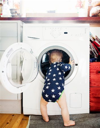 sweden baby boy - Baby boy peeking into washing machine Stock Photo - Premium Royalty-Free, Code: 6102-08566187