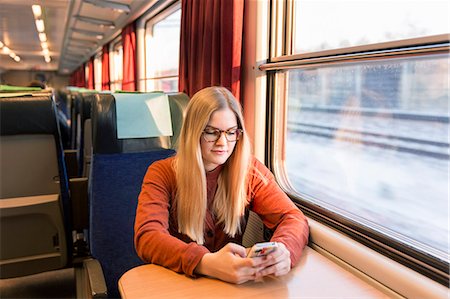 simsearch:6102-08566577,k - Young woman using cell phone in train Stock Photo - Premium Royalty-Free, Code: 6102-08566584