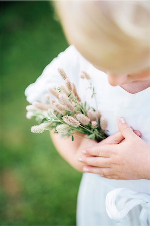 simsearch:6102-06336729,k - Girl holding wildflowers, close-up Fotografie stock - Premium Royalty-Free, Codice: 6102-08566630