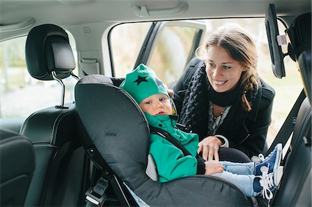 family inside car - Mother with putting baby son in car seat Foto de stock - Sin royalties Premium, Código: 6102-08566817