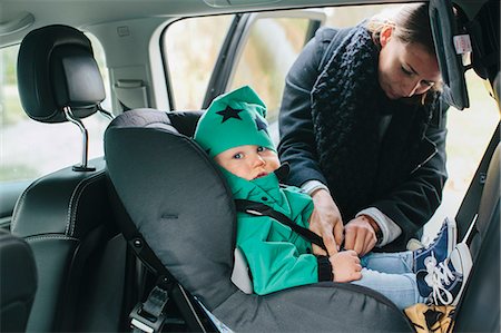 Mother with putting baby son in car seat Photographie de stock - Premium Libres de Droits, Code: 6102-08566818