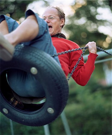 simsearch:6102-03905685,k - A man on a swing, Sweden. Stock Photo - Premium Royalty-Free, Code: 6102-08566945