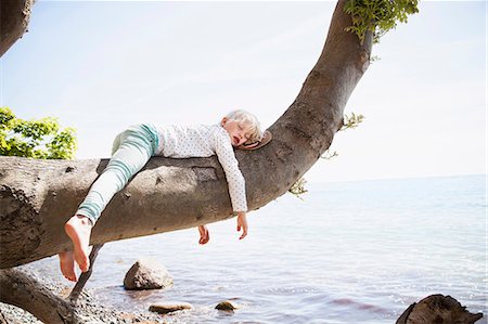 funny holidays summer - Young girl sleeping on branch by sea Stock Photo - Premium Royalty-Free, Code: 6102-08520543