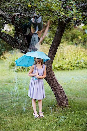pouring rain on people - Portrait of girl with umbrella standing under shower Photographie de stock - Premium Libres de Droits, Code: 6102-08520669