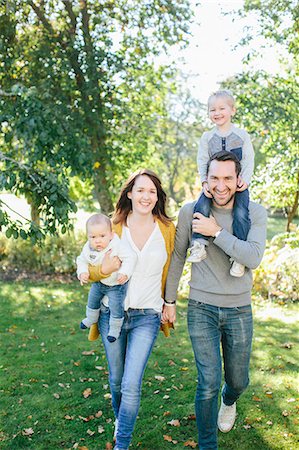female mischievous grin - Family with two children walking through park Stock Photo - Premium Royalty-Free, Code: 6102-08520746