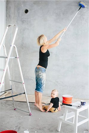 Young woman painting wall with son Stock Photo - Premium Royalty-Free, Code: 6102-08520778