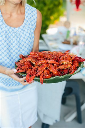 Mature woman holding bowl of crayfish Fotografie stock - Premium Royalty-Free, Codice: 6102-08520889