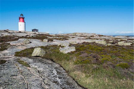 Lighthouse on rock against blue sky Stock Photo - Premium Royalty-Free, Code: 6102-08520827