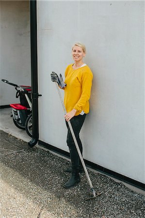 europe villa - Smiling woman holding rake Stock Photo - Premium Royalty-Free, Code: 6102-08521194