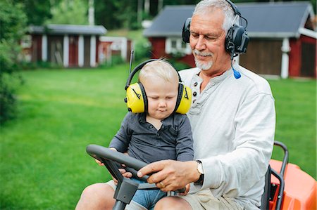 simsearch:6102-08761067,k - Grandfather with grandson on ride-on lawn mower Fotografie stock - Premium Royalty-Free, Codice: 6102-08521196