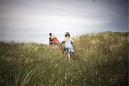 simsearch:6102-08761638,k - Mother with two daughters walking though meadow Foto de stock - Royalty Free Premium, Número: 6102-08521125