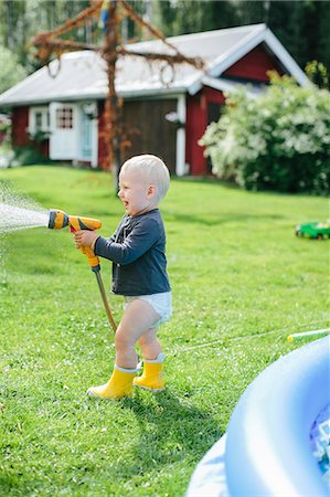 Boy with garden hose Photographie de stock - Premium Libres de Droits, Code: 6102-08521203