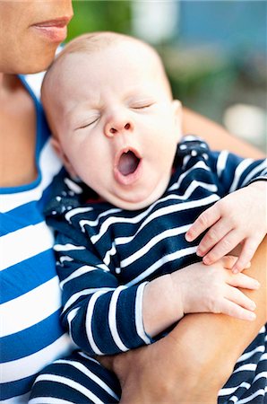 Mother holding yawning baby boy Stock Photo - Premium Royalty-Free, Code: 6102-08642012