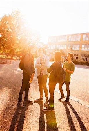 simsearch:6102-08951246,k - Teenagers standing on schoolyard Fotografie stock - Premium Royalty-Free, Codice: 6102-08746076