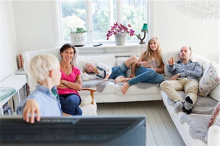 simsearch:6102-08746177,k - Family with three kids watching tv on sofa Stock Photo - Premium Royalty-Free, Code: 6102-08746176