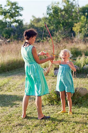 Mother and daughter playing with bow and arrow Stock Photo - Premium Royalty-Free, Code: 6102-08746133