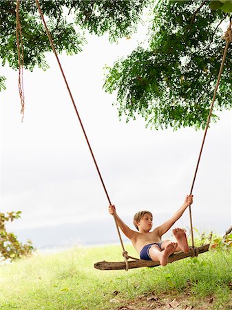 photos beach boys in asia - Boy swinging on beach Stock Photo - Premium Royalty-Free, Code: 6102-08746371
