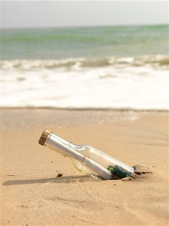 Bottle with message inside on beach Foto de stock - Royalty Free Premium, Número: 6102-08746376