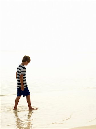 sad pic boy in water - Boy walking on beach Foto de stock - Sin royalties Premium, Código: 6102-08746379