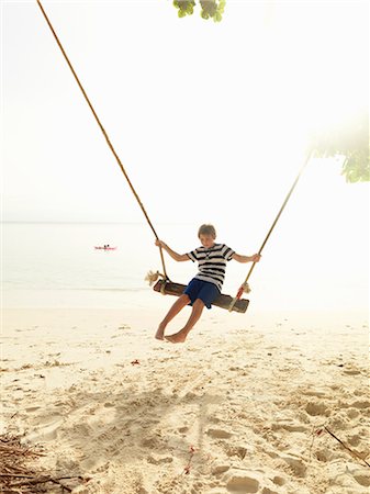 photos beach boys in asia - Boy swinging on beach Stock Photo - Premium Royalty-Free, Code: 6102-08746383